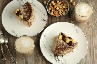 Photo of Pieces of delicious Kyiv Cake served with coffee on wooden table, flat lay