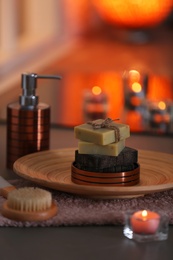 Bottle of shampoo and soap bars on table against blurred background