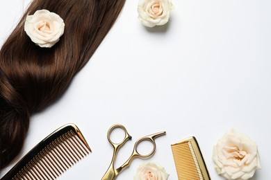 Hairdresser tools. Brown hair lock, combs, scissors and flowers on white background, flat lay. Space for text