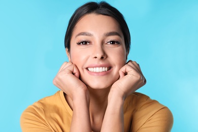 Young woman with healthy teeth on color background