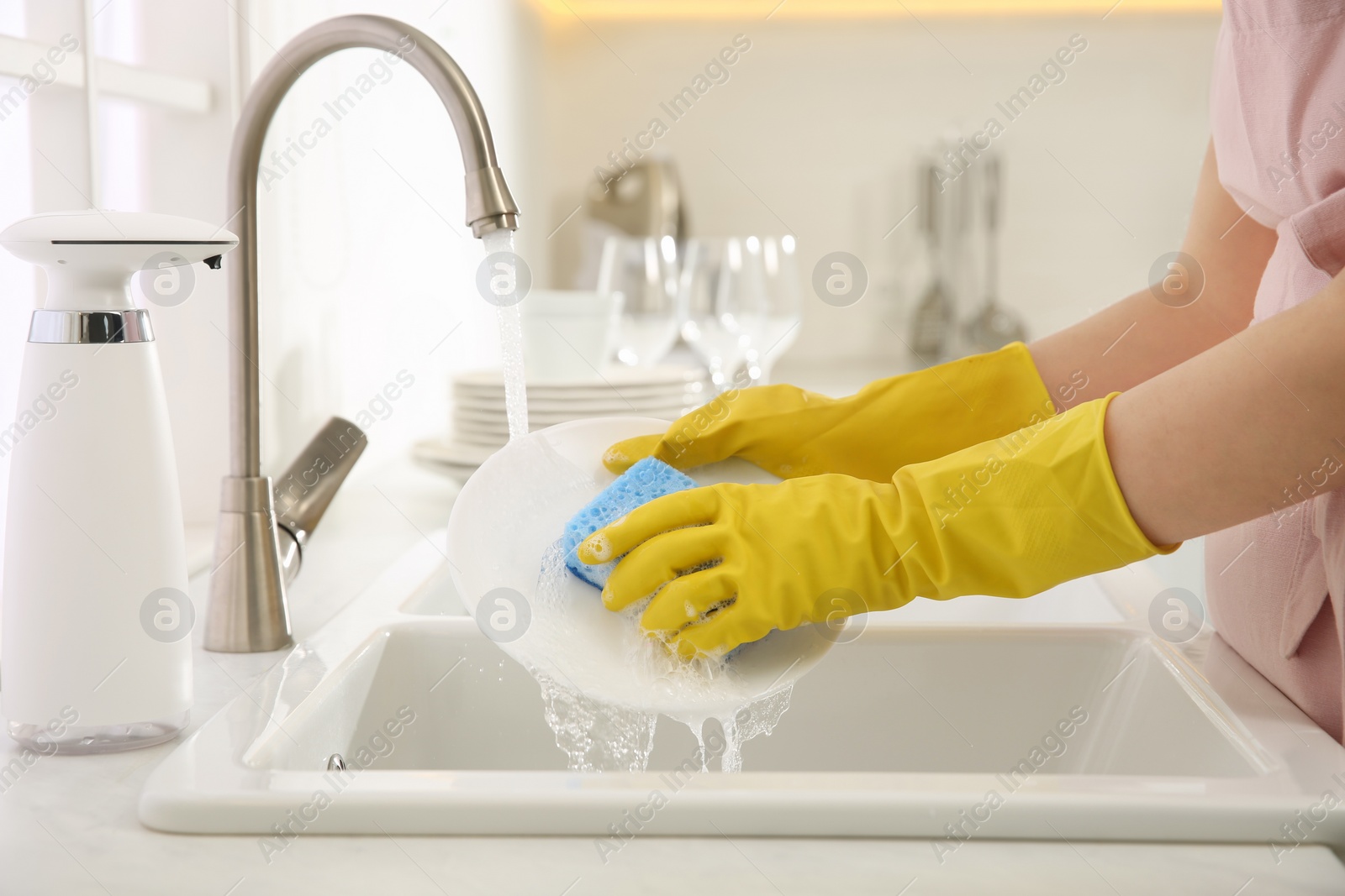 Photo of Woman washing plate in modern kitchen, closeup