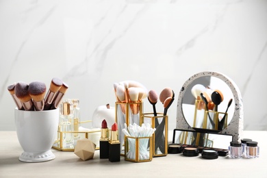 Photo of Set of makeup products and brushes on table