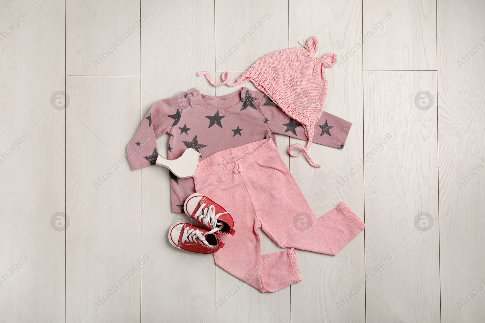 Photo of Flat lay composition with cute clothes on wooden background. Baby accessories