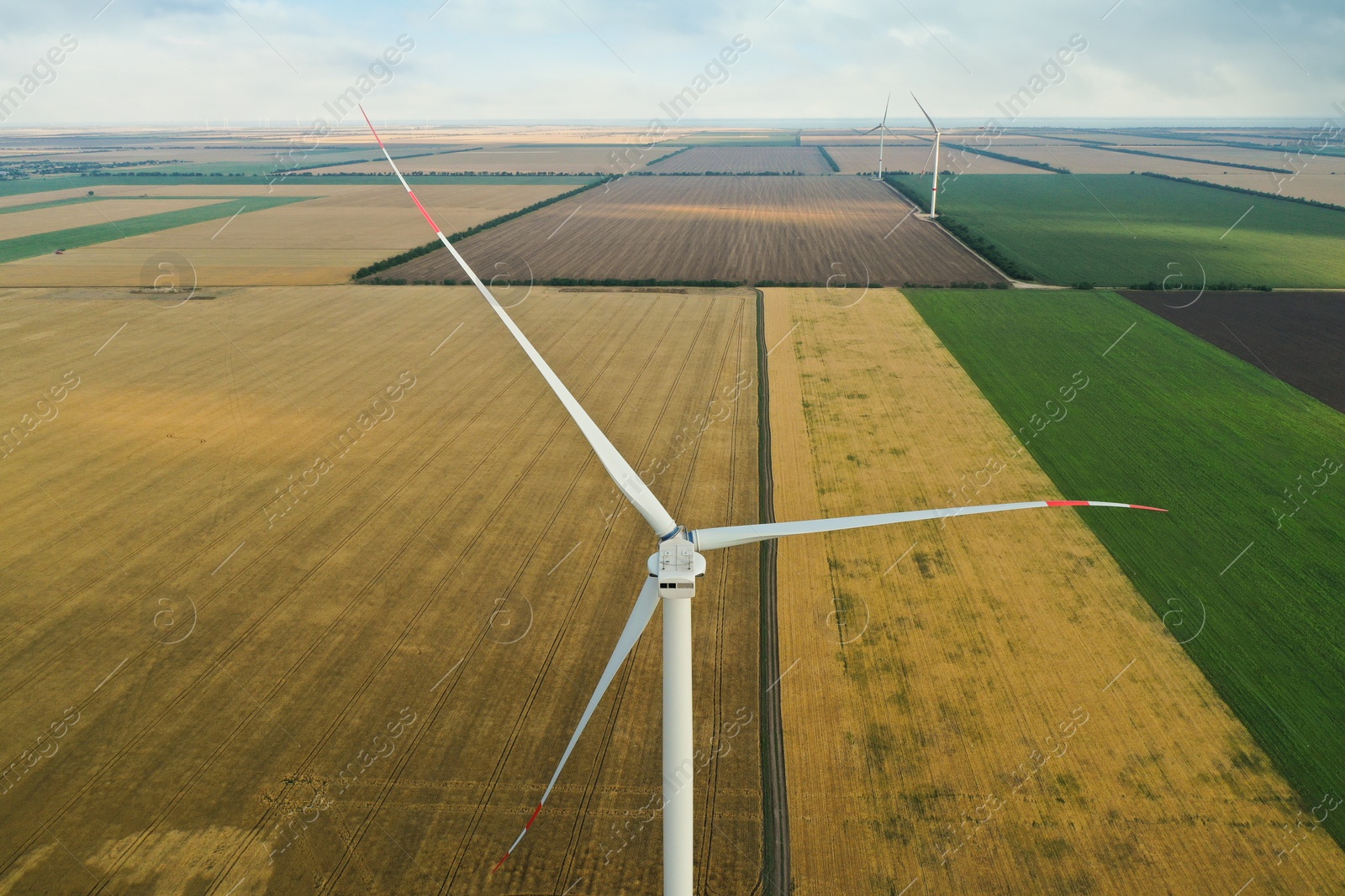 Photo of Modern windmill in wide field. Energy efficiency