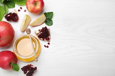 Honey, pomegranate and apples on white wooden table, flat lay with space for text. Rosh Hashana holiday