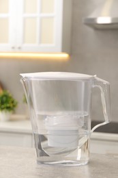 Photo of Water filter jug on light grey table in kitchen