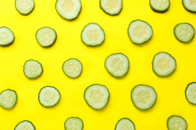 Photo of Slices of fresh ripe cucumber on yellow background, flat lay