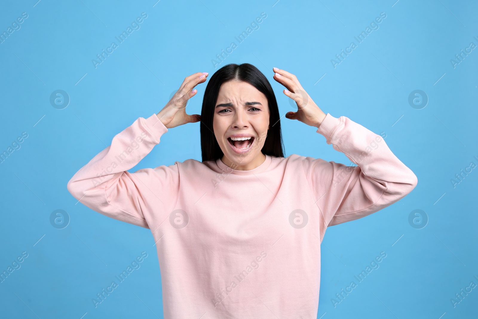 Photo of Portrait of stressed young woman on light blue background