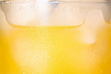 Photo of Glass of refreshing drink with ice cubes on light background, closeup
