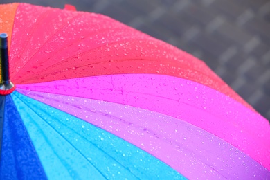 Photo of Bright color umbrella under rain outdoors, closeup