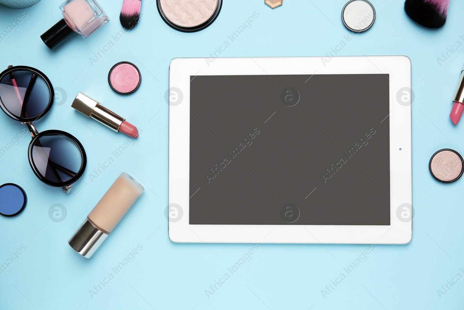 Photo of Flat lay composition with tablet and makeup products for woman on color background
