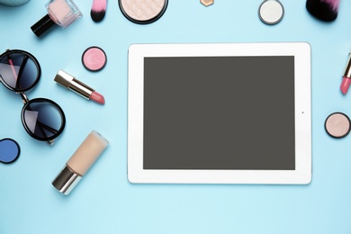 Flat lay composition with tablet and makeup products for woman on color background