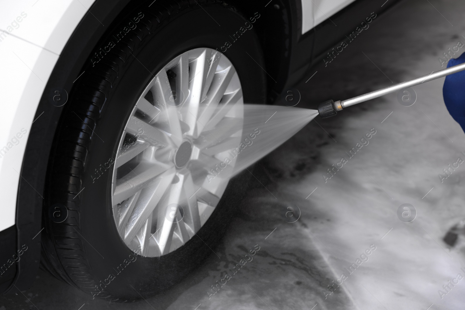 Photo of Washing auto with high pressure water jet at outdoor car wash, closeup