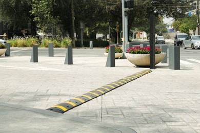 Photo of City street with striped plastic speed bump