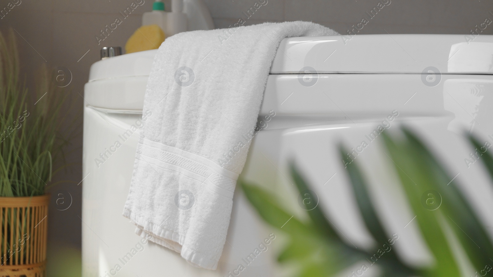 Photo of Soft fluffy towel hanging on bathtub indoors