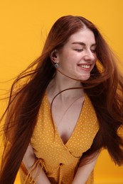 Photo of Portrait of smiling woman on yellow background