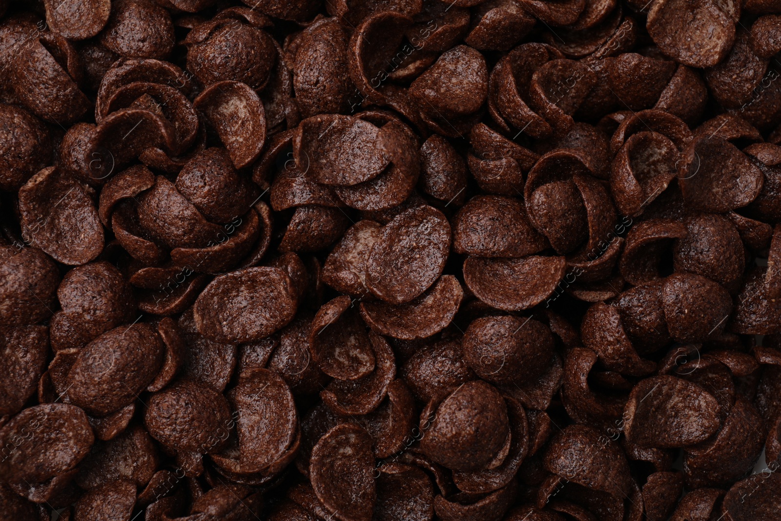 Photo of Breakfast cereal. Tasty chocolate corn flakes as background, top view