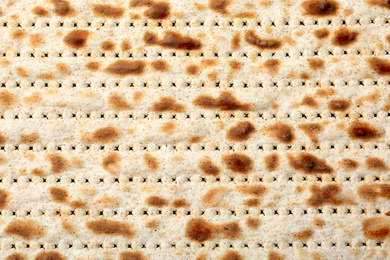 Photo of Traditional Matzo as background, top view. Pesach (Passover) celebration