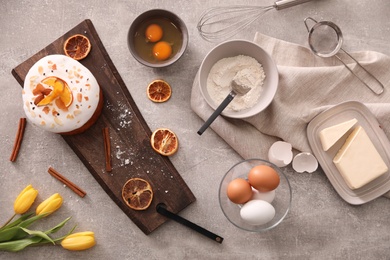 Photo of Flat lay composition with Easter cake and ingredients on light grey table