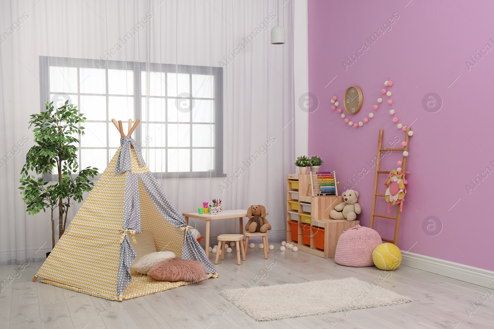 Photo of Modern nursery room interior with play tent for kids