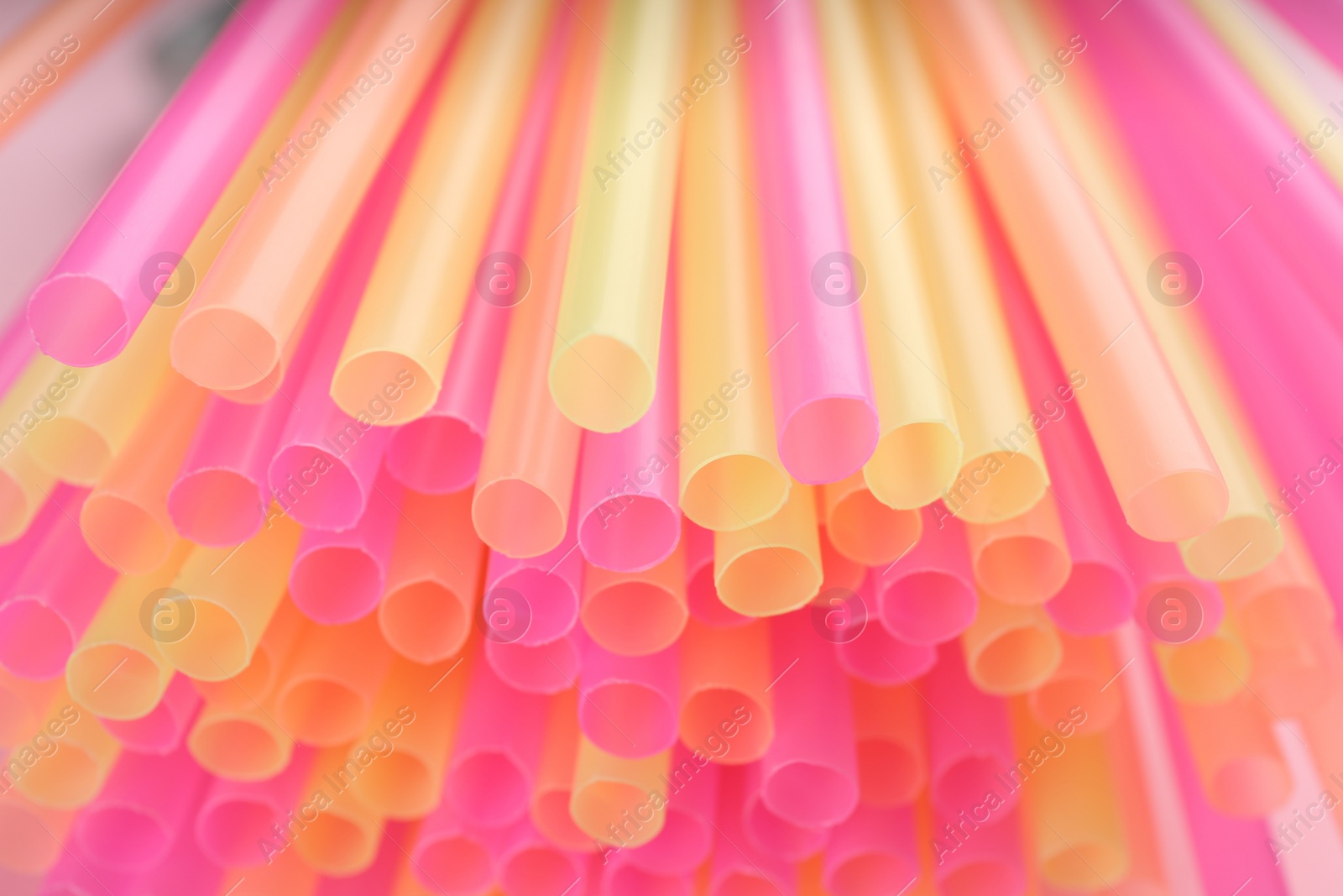 Photo of Heap of colorful plastic straws for drinks as background, closeup