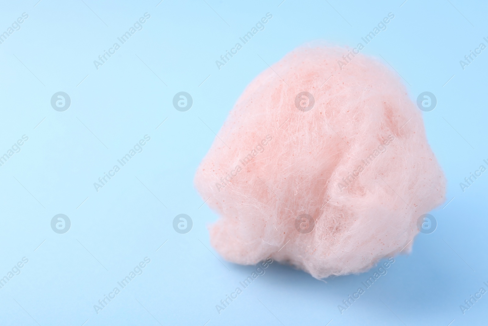 Photo of One sweet cotton candy on light blue background. Space for text