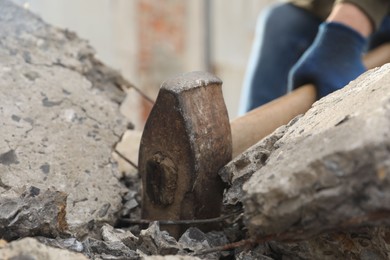 Man breaking stones with sledgehammer outdoors, closeup