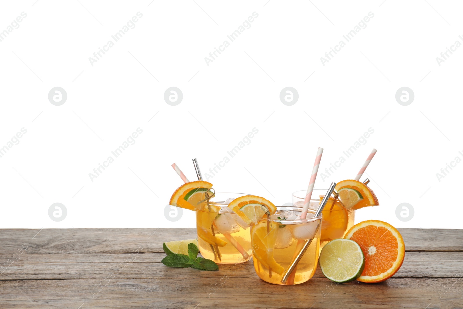 Photo of Delicious refreshing drink with orange and lime slices on wooden table against white background