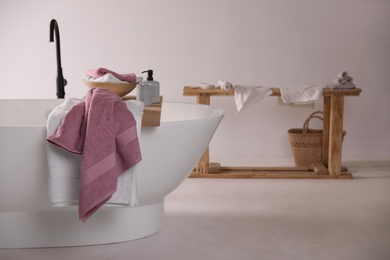 Image of Soft towels on wooden board in bathroom, space for text. Interior design