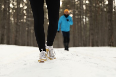 People running in winter forest, closeup. Outdoors sports exercises