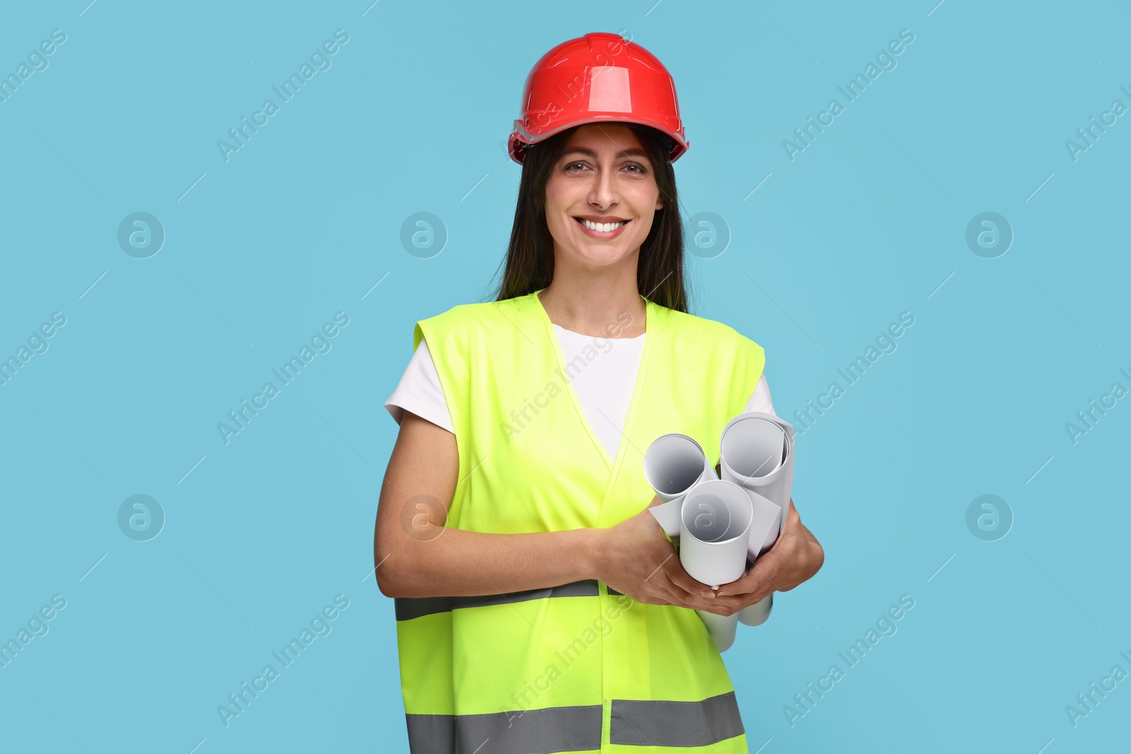 Photo of Architect in hard hat with drafts on light blue background