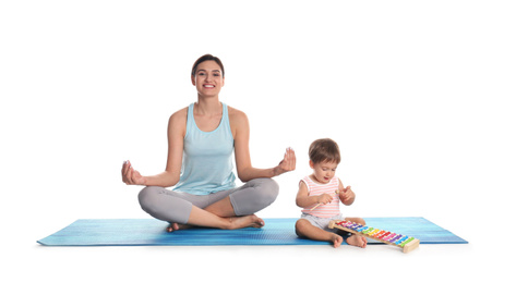 Young woman meditating while her son playing with toy xylophone isolated on white