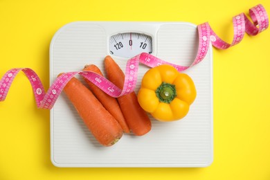 Photo of Flat lay composition with scales and vegetables on yellow background