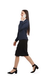 Photo of Young businesswoman talking on smartphone while walking against white background