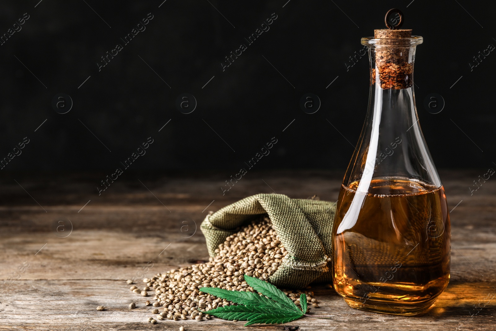 Photo of Composition with hemp oil on wooden table