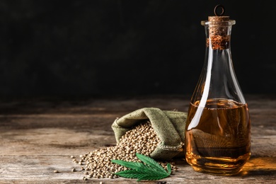 Photo of Composition with hemp oil on wooden table