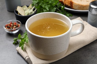 Hot delicious bouillon in cup on grey table