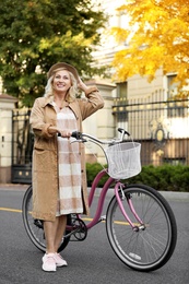 Photo of Mature woman with bicycle outdoors. Active lifestyle