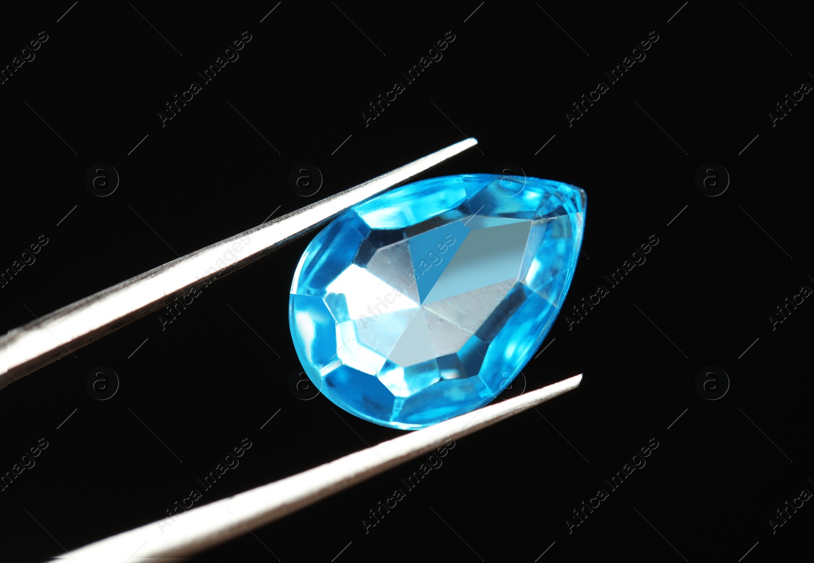 Photo of Tweezers with beautiful gemstone on black background