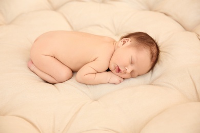 Adorable newborn baby sleeping on bed