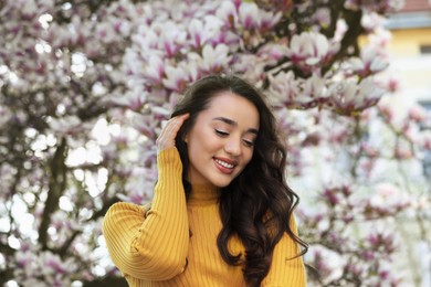 Photo of Beautiful woman near blossoming magnolia tree on spring day