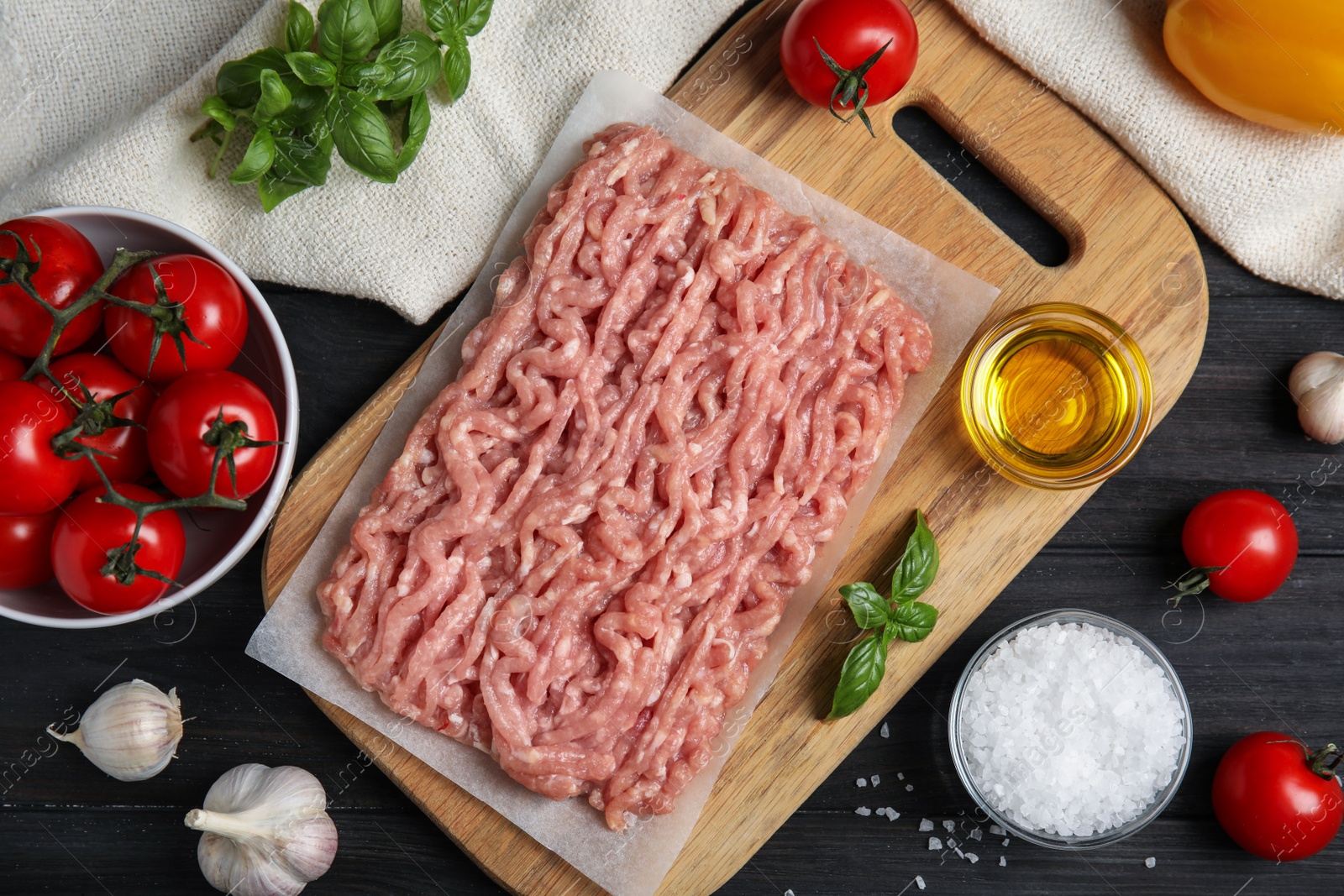 Photo of Raw chicken minced meat and ingredients on black wooden table, flat lay