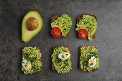 Photo of Tasty crisp rye toasts with avocado on table, flat lay