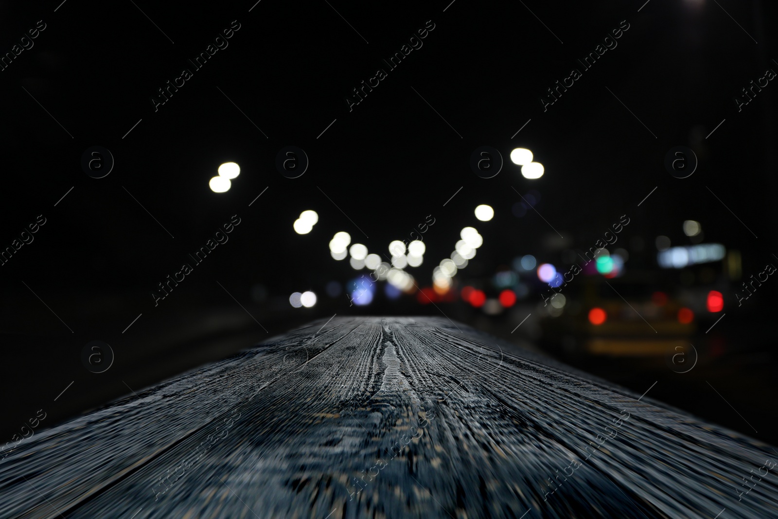 Image of Empty wooden surface and blurred view of night city