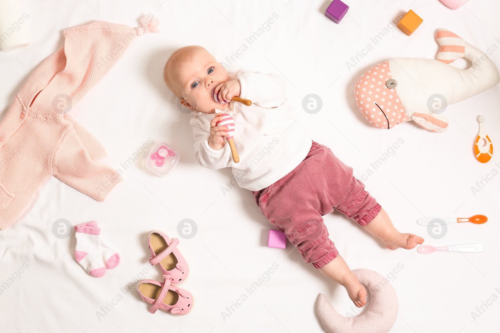 Photo of Cute little baby with clothing and accessories on white background, top view