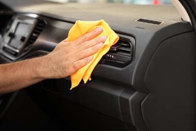 Photo of Man cleaning car interior with rag, closeup