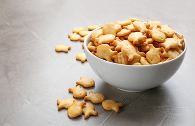 Photo of Delicious goldfish crackers in bowl on grey table
