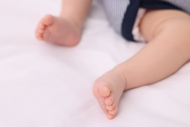 Photo of Newborn baby lying on white blanket, closeup