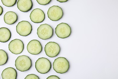 Fresh slices of cucumbers on white background, top view. Space for text