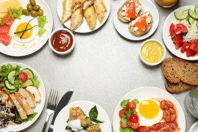 Buffet service. Frame of many different dishes on light grey table, space for text